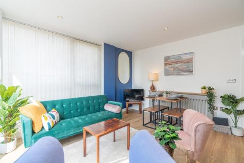 - un salon avec un canapé vert et des chaises dans l'établissement Queen Anne House near Gunwharf Quays, Portsmouth with FREE PARKING, à Portsmouth