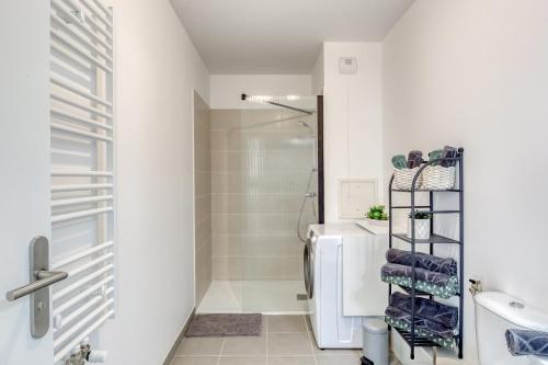 a white bathroom with a shower and a toilet at 44m² - Cosy - Neuf - Parking in Massy