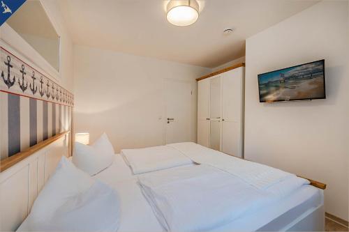 ヘリングスドルフにあるVilla Doris Whg 2 Morgensonneのベッドルーム(白いベッド、白い枕付)