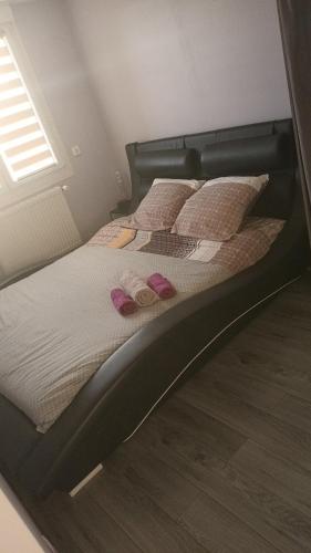 - un lit avec des chaussons roses dans l'établissement Maison en ville, à Grande-Synthe
