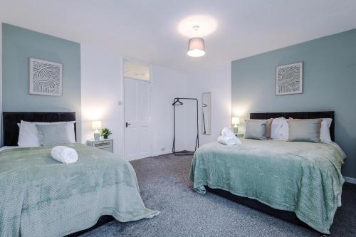 two beds sitting next to each other in a bedroom at Stylish House in Manchester Sleeps7 Wifi & Parking by PureStay in Manchester