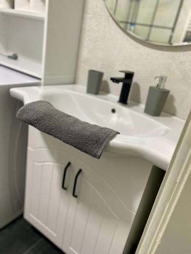 W białej łazience znajduje się umywalka i lustro. w obiekcie Like Home w mieście Arad