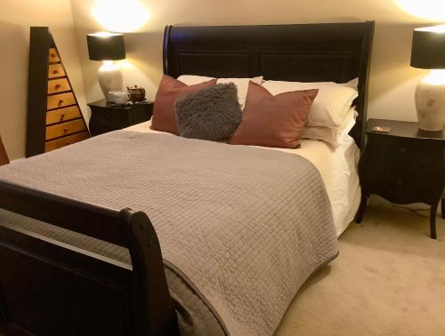 een slaapkamer met een groot bed met kussens bij Holmlea Cottage in Moffat