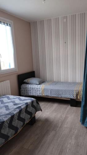 une chambre avec deux lits et une fenêtre dans l'établissement la petite cabane, à Maillé
