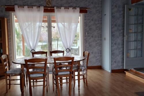 a dining room with a table and chairs and a window at la petite cabane in Maillé