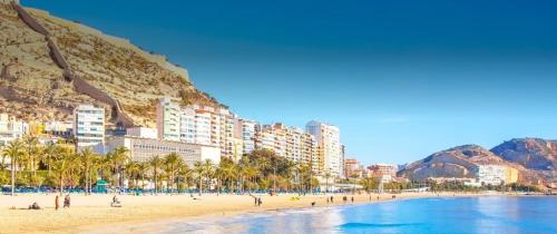 a beach with a group of people and buildings at Elegance Apartment in Alicante