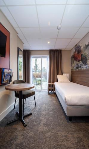 a hotel room with a bed and a desk and a table at Fletcher Hotel Restaurant Doorwerth - Arnhem in Doorwerth