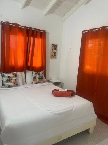 a bedroom with a large bed with orange curtains at Casita de 2 habitaciones in Las Terrenas