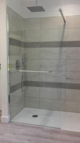 une salle de bain avec une douche avec une porte vitrée dans l'établissement Maison calme proche Périgueux et piscine chauffée, à Agonac