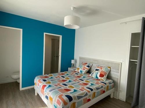 - une chambre avec des murs bleus et un lit avec des oreillers dans l'établissement Maison calme proche Périgueux et piscine chauffée, à Agonac