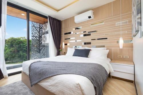 a bedroom with a large bed and a large window at Appartements avec piscine in Rawai Beach