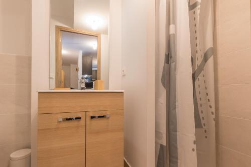 La salle de bains est pourvue d'une armoire en bois et d'un miroir. dans l'établissement La Maya - Appt vue montagne, à Vars