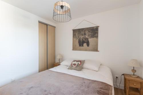 - une chambre avec un lit et une photo d'éléphant dans l'établissement La Maya - Appt vue montagne, à Vars