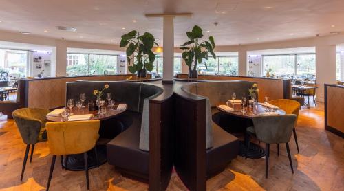 a restaurant with two tables and chairs in a room at Fletcher Hotel Restaurant Doorwerth - Arnhem in Doorwerth