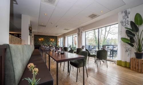 a restaurant with a long table and chairs at Fletcher Hotel Restaurant Doorwerth - Arnhem in Doorwerth
