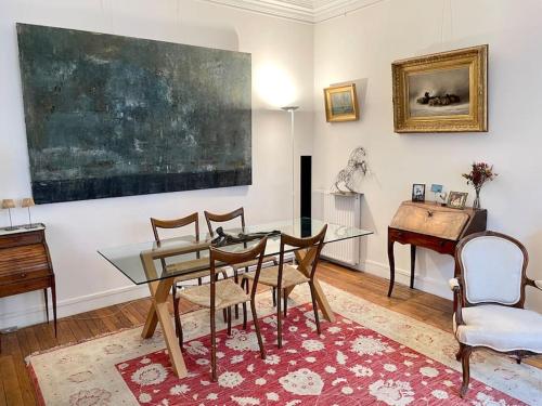 a dining room with a glass table and a piano at Grand appartement Champ de Mars in Paris