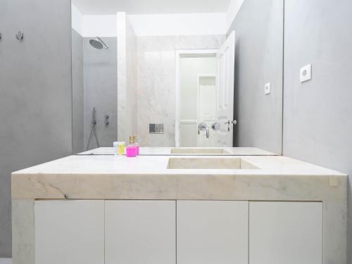 a white bathroom with a sink and a shower at Akicity Lisboa Iris in Lisbon