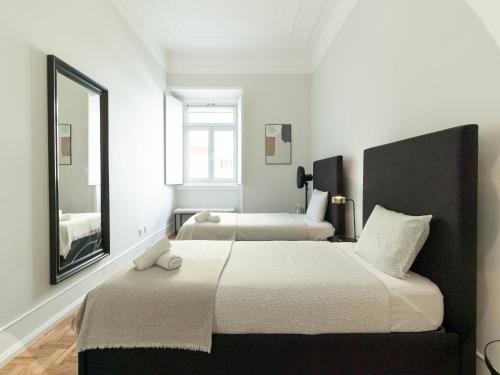 sypialnia z 2 łóżkami i dużym lustrem w obiekcie Akicity Lisboa Iris w Lizbonie