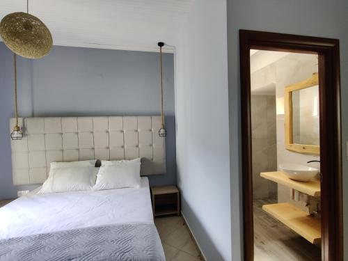 a bedroom with a bed and a mirror and a sink at Verde Villas in Skala Potamias