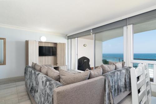 a living room with a couch and a television at Chakas Cove 38 in Ballito