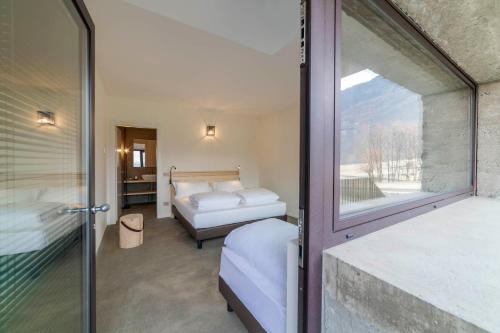 a bedroom with two beds and a window at Agriturismo B&B Caffè e Vino in Sondrio