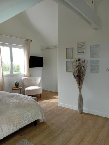 a bedroom with a bed and a vase of flowers at Domaine du D-DAY in Saint-Côme-du-Mont