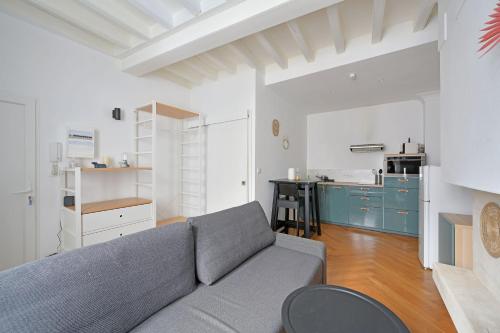 un salon avec un canapé et une cuisine dans l'établissement Studio Marie - Proche Théatres et Place des corps saints - WIFI, à Avignon