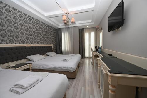 Habitación de hotel con 2 camas y TV de pantalla plana. en Albatros İstanbul en Estambul