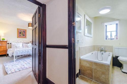 a bathroom with a tub and a toilet and a sink at Spacious 5BR Home w/Game Room in Ruthin