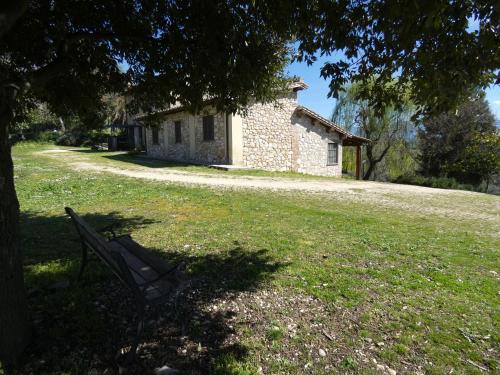 un banc assis dans l'herbe devant un bâtiment dans l'établissement Scappo in Umbria, Collefiorito, à Rocchette