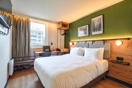 a hotel room with a large bed and a desk at Campanile Paris Ouest - Pont de Suresnes in Suresnes