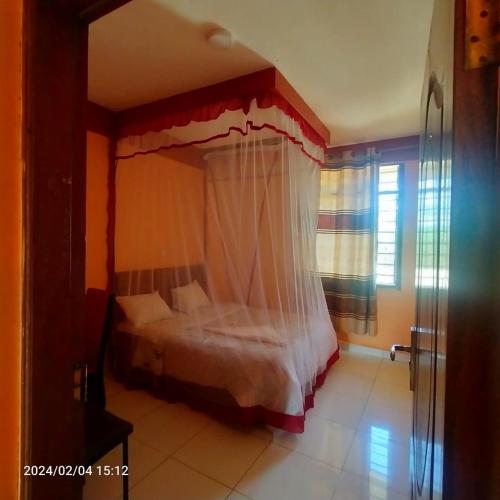 a bedroom with a canopy bed in a room at comfort zone Hotel voi in Voi