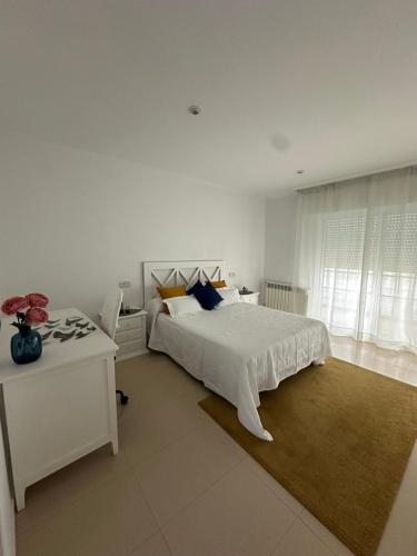 ノアリャにあるVivienda Cousillasの白いベッドルーム(白いベッド1台、テーブル付)