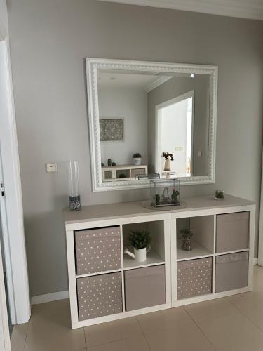 biała komoda z lustrem w pokoju w obiekcie Vivienda Cousillas w mieście Noalla