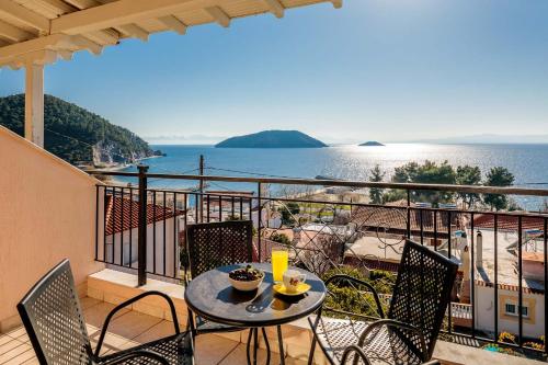 a table and chairs on a balcony with a view of the ocean at Belvedere Skopelos in Neo Klima