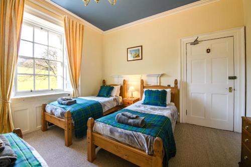 een slaapkamer met 2 bedden en een raam bij Dunfallandy House Hotel in Pitlochry