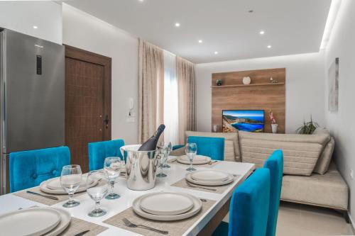 a dining room with a table and blue chairs at Valeria Private Villa in Plános