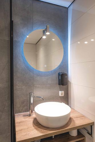 a bathroom with a white sink and a mirror at De Klomp Charme Hotel & Restaurant in Vilsteren