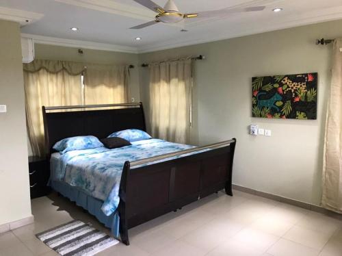 1 dormitorio con 1 cama y ventilador de techo en Villa at Grace, en Cape Coast