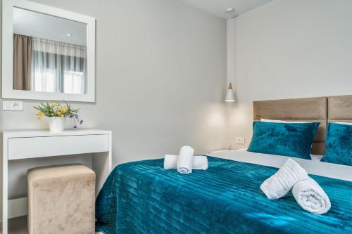 a bedroom with a blue bed and a mirror at Valeria Private Villa in Plános