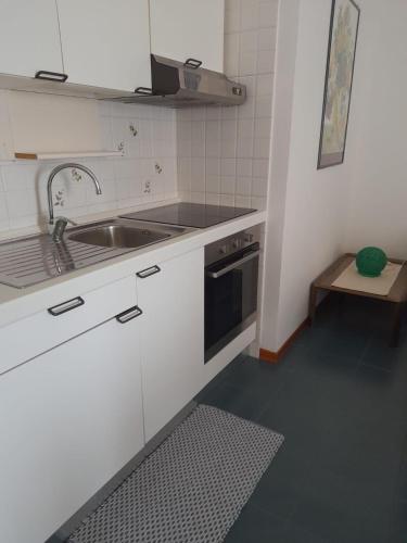 a small kitchen with a sink and a stove at Residence Porto Coda Cavallo in San Teodoro