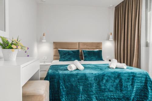 a hotel room with a bed with blue sheets and towels at Valeria Private Villa in Plános