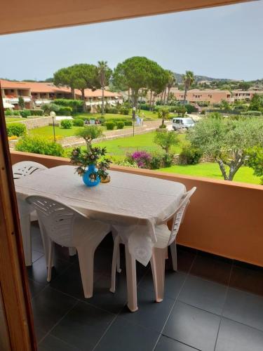 a white table and chairs in a room with a window at Residence Porto Coda Cavallo in San Teodoro