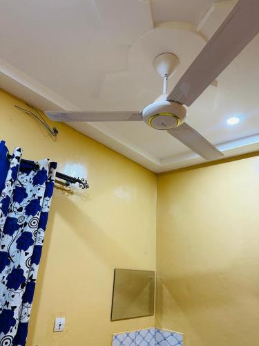 a ceiling fan in a room with a blue at Villa meublée climatisé en cours unique in Ouagadougou