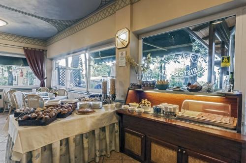 a restaurant with a table with food on it at Hotel Kursaal in Passignano sul Trasimeno