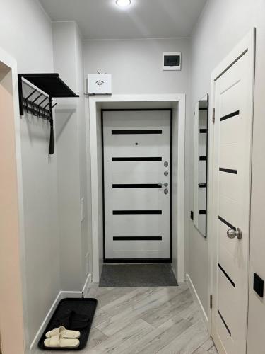 a hallway with a door and a dog bed on the floor at Новый ЖК на Байзакова in Pavlodar
