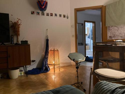 ein Wohnzimmer mit Holzboden und ein Zimmer mit einem Tisch in der Unterkunft Zimmer in WG in Fürstenfeldbruck