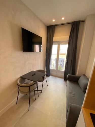 a living room with a table and a couch at Apartamentos "El collado Suites" Soria Centro in Soria