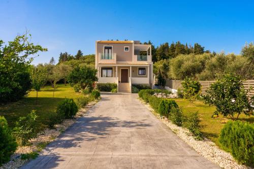 a large white house with a driveway at Valeria Private Villa in Plános