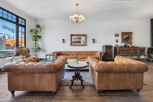 a living room with two leather couches and a table at The Historic Grand Canyon Hotel in Williams